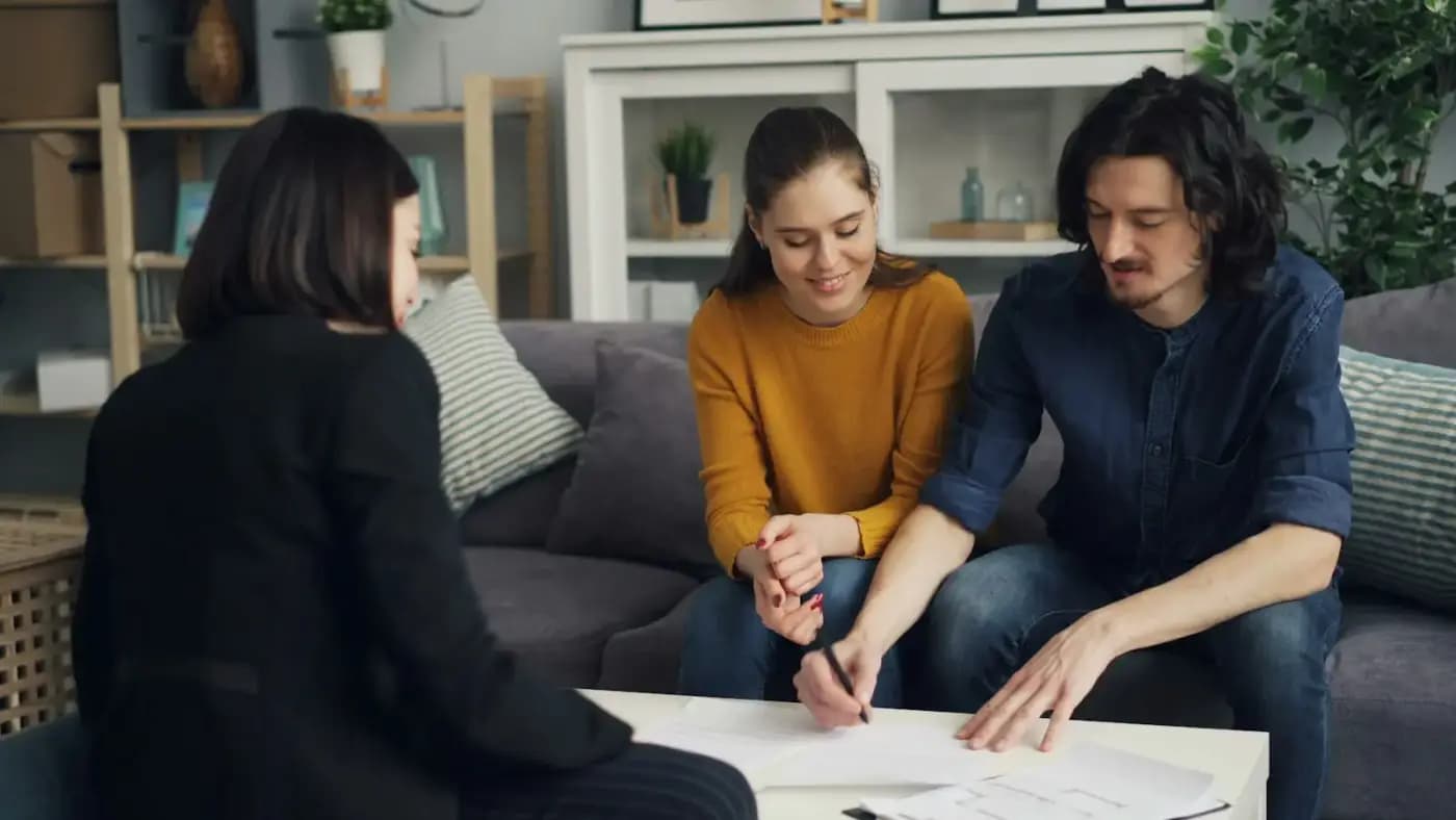 Une conseillère et un couple signent un compromis